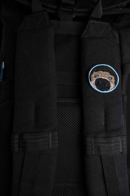 Patch brodat rotund cu față de câine în centru pe fundal negru, un accesoriu amuzant pentru iubitorii de animale.
