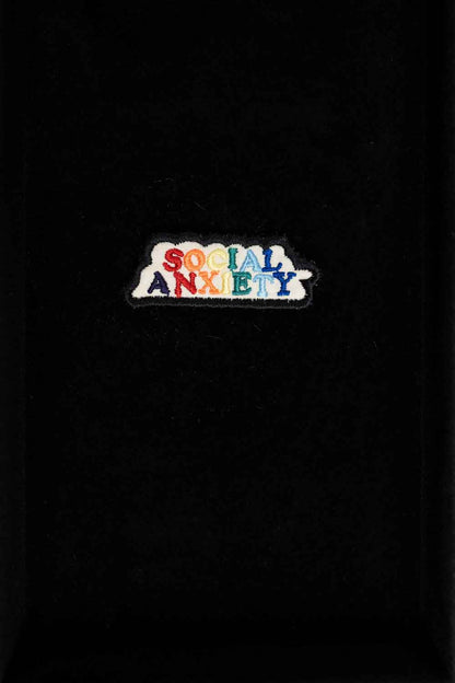 Patch brodat negru cu mesajul „Social Anxiety”, un accesoriu expresiv și ironic pentru personalizarea hainelor sau genților.