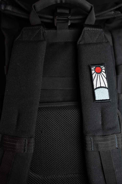 Patch brodat inspirat de universul anime, cu design roșu și alb asemănător unui simbol solar, un accesoriu pentru fanii culturii japoneze.