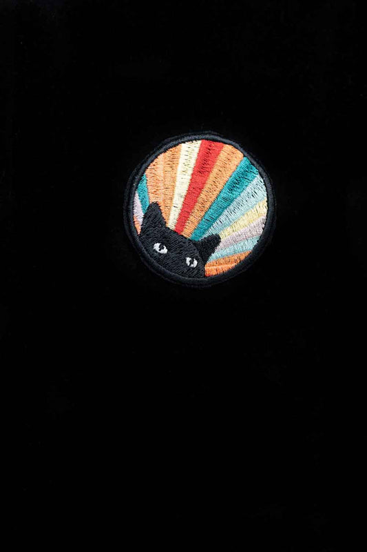 Patch brodat cu design circular multicolor și o pisică neagră în centru, un accesoriu artistic cu aspect misterios.