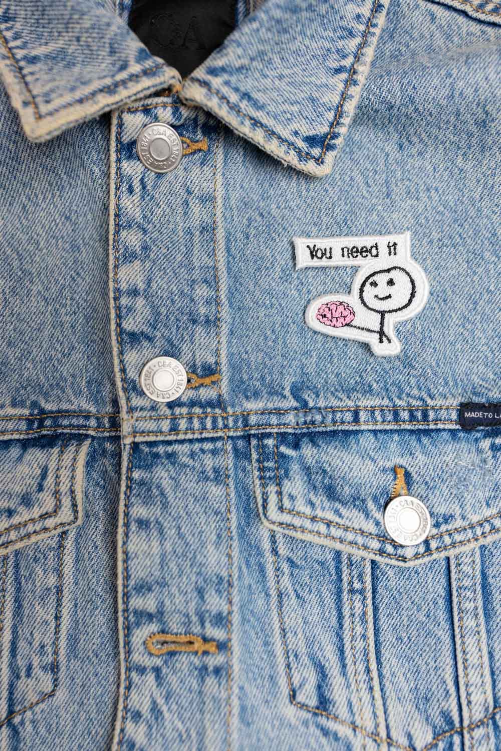 Patch brodat cu personaj colorat și mesajul „You Need It”, un accesoriu creativ și amuzant pentru personalizare.