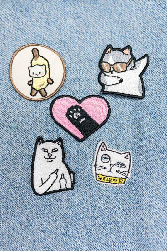Set de cinci patch-uri brodate cu design inspirat de pisici, prezentate pe material din denim, ideale pentru personalizarea hainelor și accesoriilor.