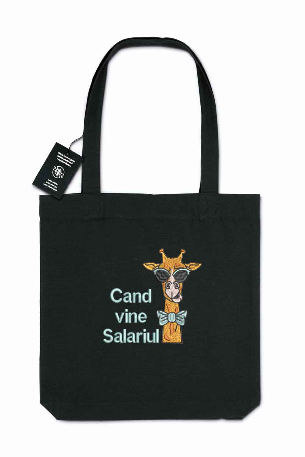 Tote bag brodat negru cu ilustrație amuzantă de girafă purtând ochelari de soare și papion, alături de mesajul „Când vine salariul”, purtat în aer liber.