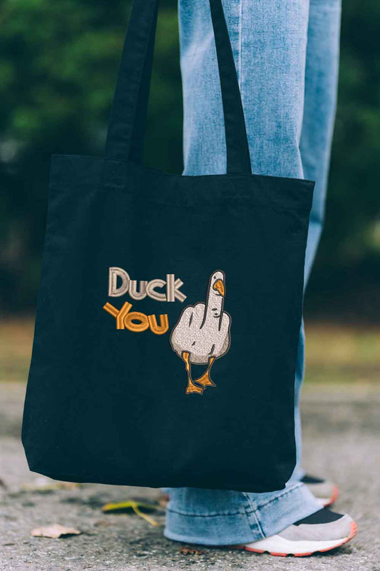Tote bag brodat negru cu textul „Duck You” și ilustrație amuzantă cu o rață, un design ironic și jucăuș purtat în aer liber.