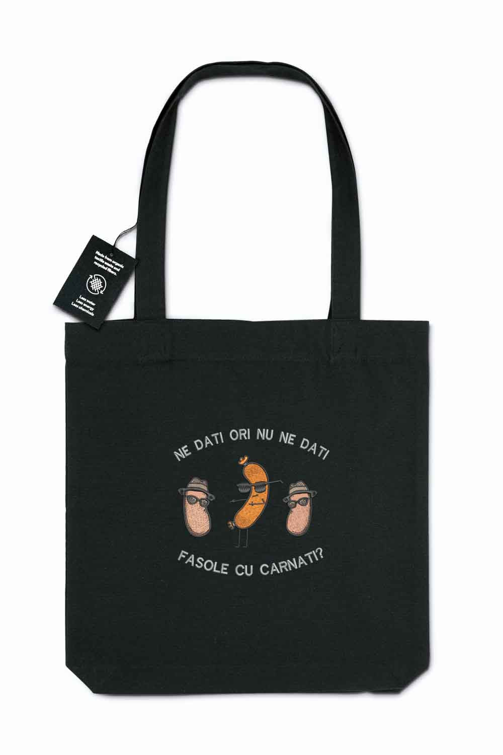 Tote bag brodat negru cu ilustrație amuzantă cu boabe de fasole purtând pălării și ochelari de soare și mesajul românesc „Ne dați ori nu ne dați fasole cu cârnați?”, purtat în aer liber.