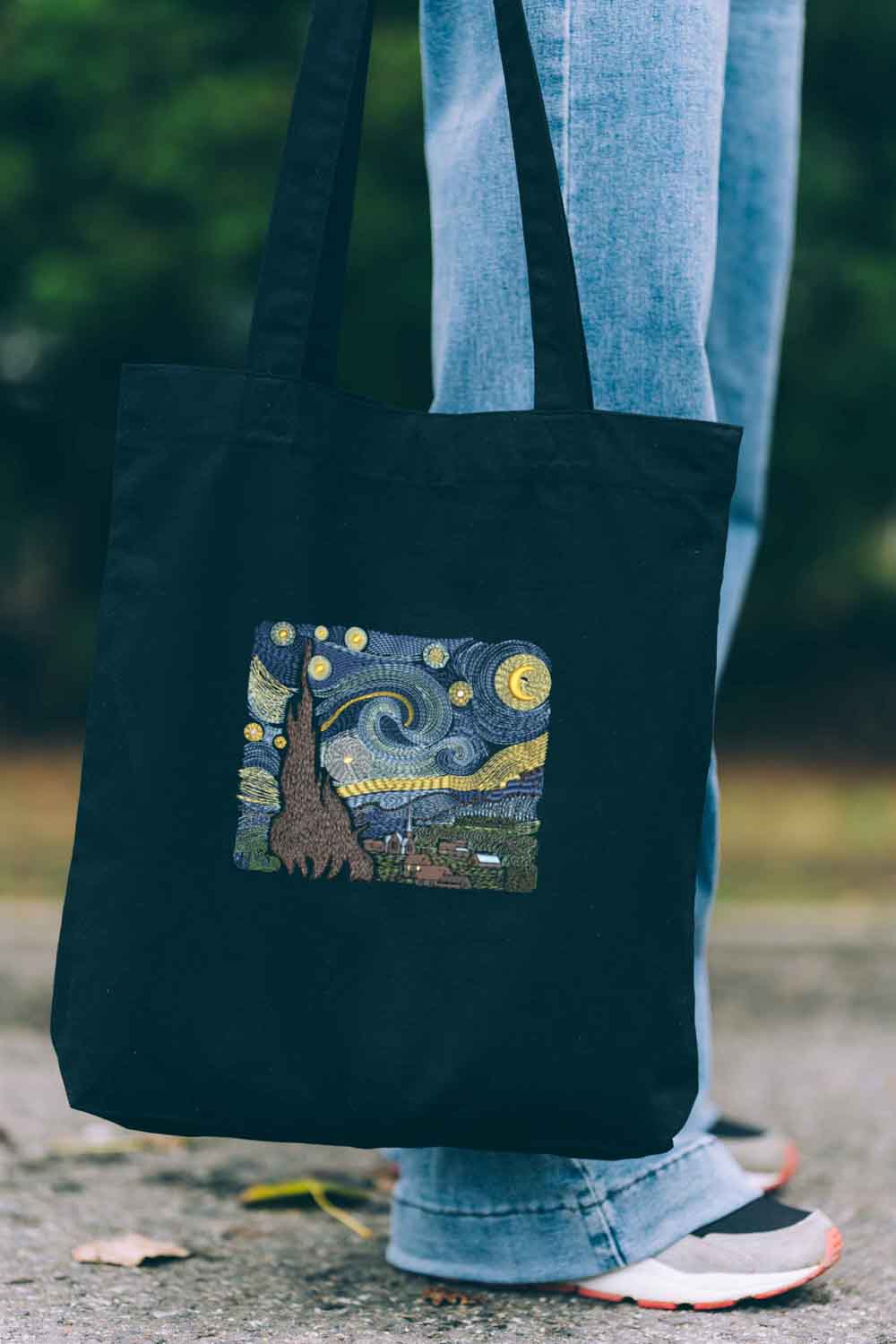 Tote bag brodat negru cu design inspirat de „Starry Night”, o reinterpretare  a operei lui Van Gogh, purtat în aer liber.
