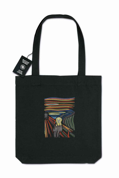 Tote bag brodat negru cu design colorat reprezentând un dinte înconjurat de pene, inspirat de „The Scream”, purtat în aer liber.